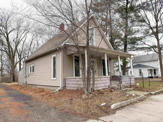 view of front of property with covered porch and a chimney