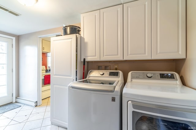 washroom featuring a healthy amount of sunlight, a baseboard radiator, visible vents, and washer and clothes dryer