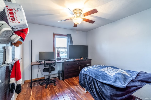 bedroom featuring wood finished floors, a ceiling fan, and baseboards