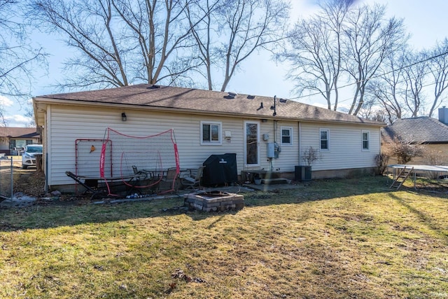 rear view of house with a trampoline, cooling unit, and a yard