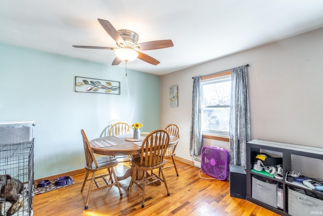 dining room featuring ceiling fan, baseboards, and light wood-style floors