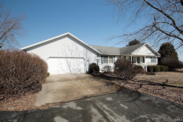 view of front of home featuring driveway, a garage, and a porch