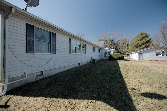 view of side of home featuring crawl space, a lawn, and central air condition unit