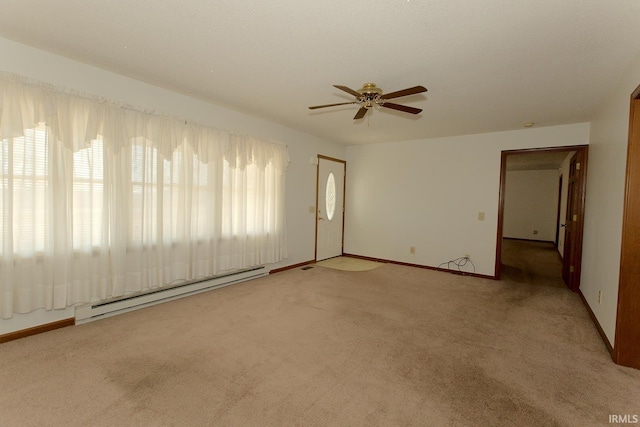 spare room featuring light carpet, ceiling fan, baseboard heating, and baseboards