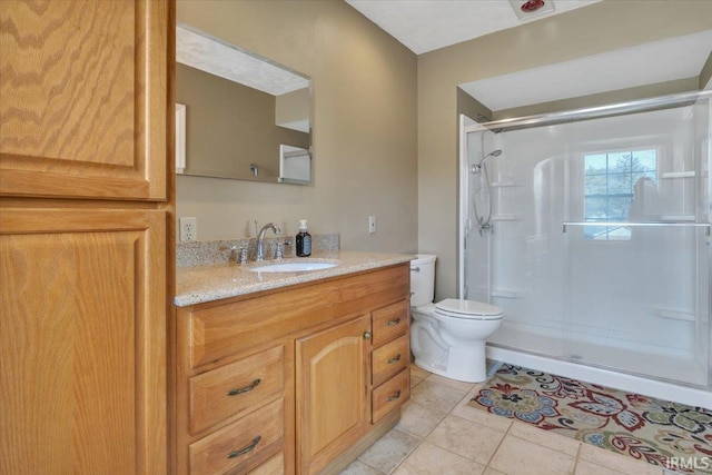 full bathroom featuring a stall shower, tile patterned flooring, vanity, and toilet