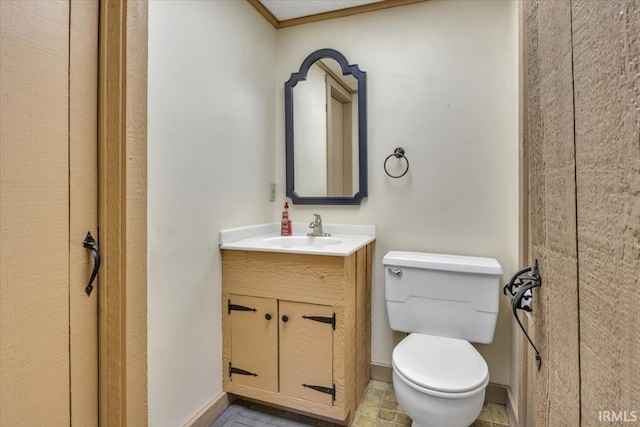 bathroom with baseboards, vanity, and toilet