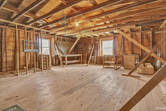 unfinished attic with a wealth of natural light and an upstairs landing