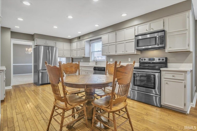 kitchen with light countertops, appliances with stainless steel finishes, light wood-type flooring, and recessed lighting