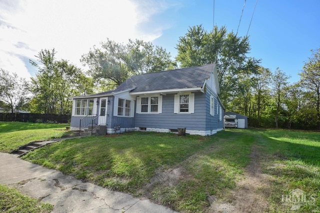 view of front of house featuring a shingled roof, fence, and a front yard