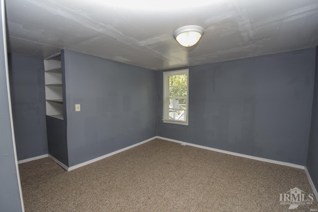 carpeted empty room with baseboards