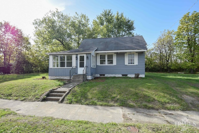 view of front of house featuring a front lawn and roof with shingles