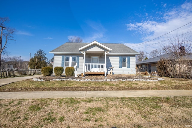 bungalow-style house featuring covered porch, a front yard, and fence