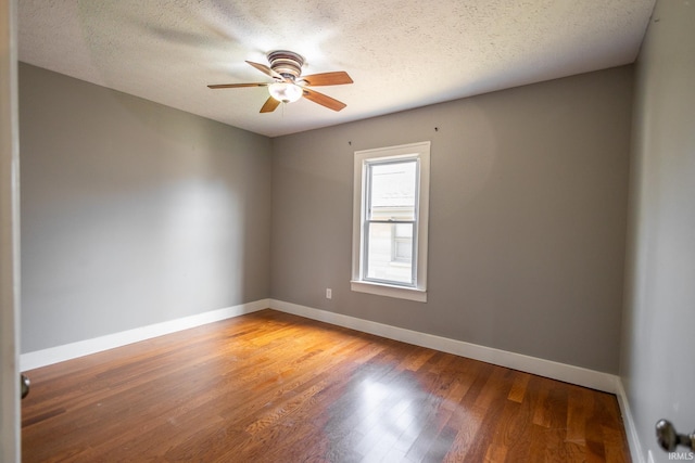 spare room with light wood-style flooring, baseboards, and a textured ceiling