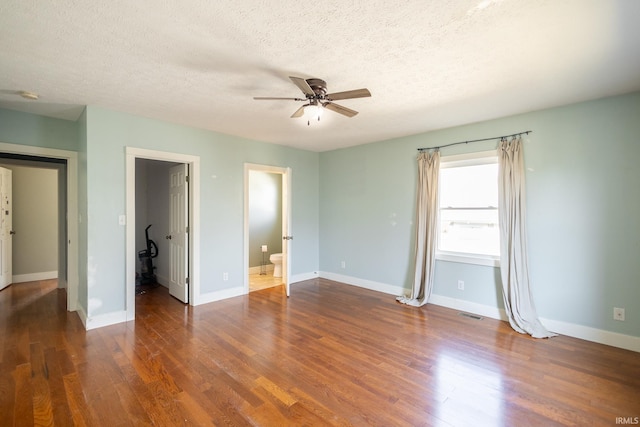 unfurnished bedroom featuring a ceiling fan, a textured ceiling, baseboards, and wood finished floors