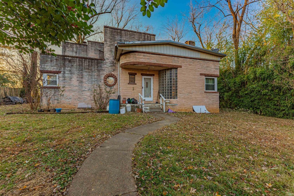 220 N 4th St, Rockport, IN 47635 - view of front facade with a front lawn and brick siding
