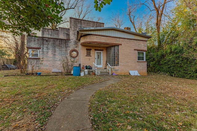 view of front facade with a front lawn and brick siding