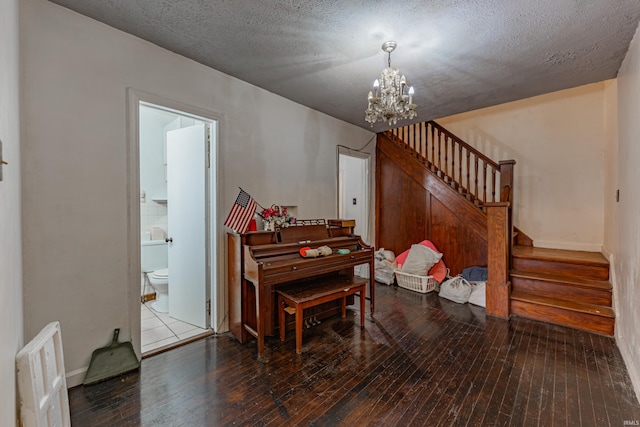 interior space with hardwood / wood-style flooring, a textured ceiling, an inviting chandelier, and stairs