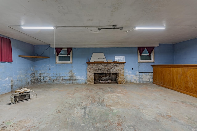 finished basement with a fireplace and concrete block wall