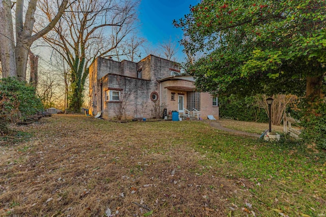 view of front of property featuring brick siding and a front yard