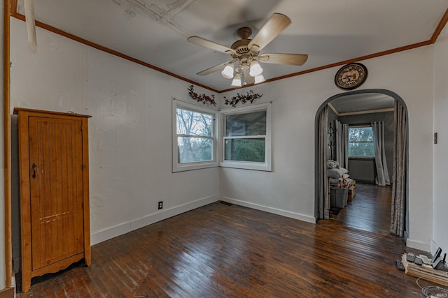 unfurnished room with arched walkways, wood-type flooring, a wealth of natural light, and crown molding