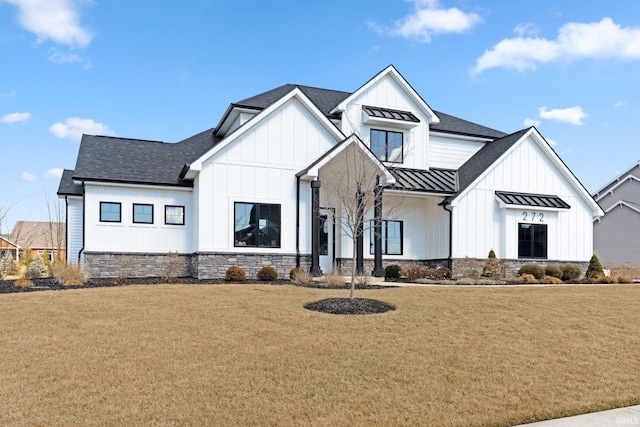 modern farmhouse style home with a front lawn, a standing seam roof, and board and batten siding