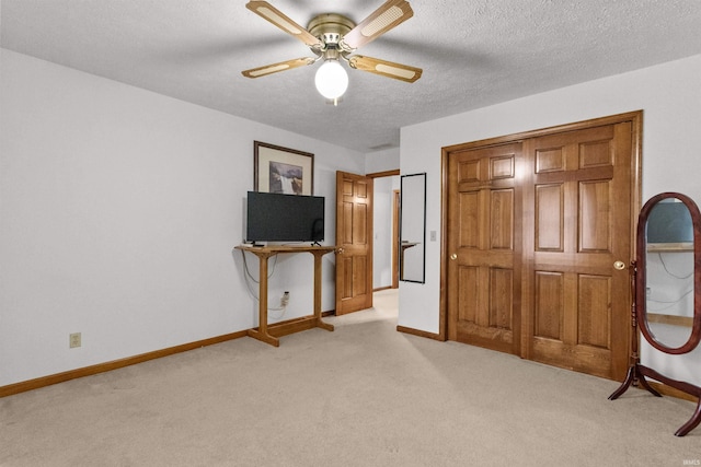 unfurnished bedroom with light carpet, baseboards, and a textured ceiling