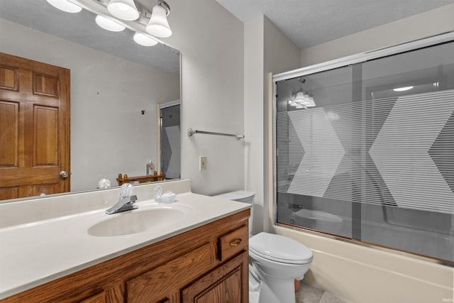 bathroom with enclosed tub / shower combo, vanity, and toilet