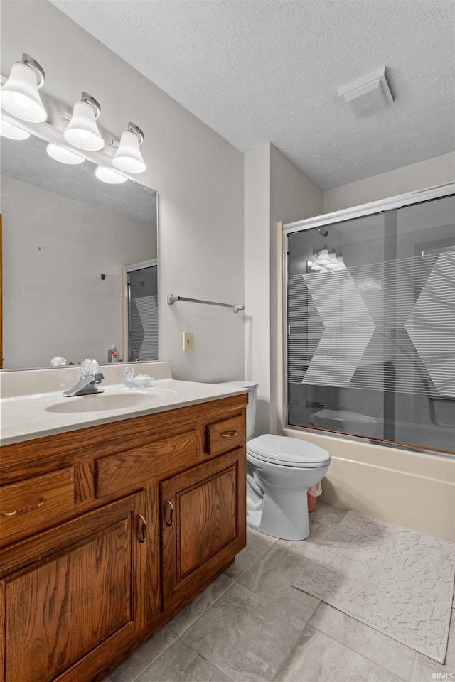 full bath featuring combined bath / shower with glass door, a textured ceiling, toilet, and vanity