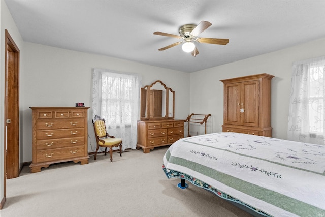 bedroom featuring a ceiling fan and light carpet