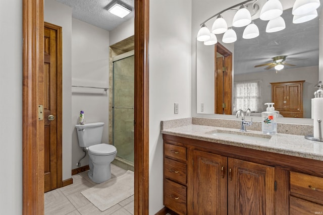 full bathroom featuring toilet, a ceiling fan, vanity, a shower stall, and a textured ceiling