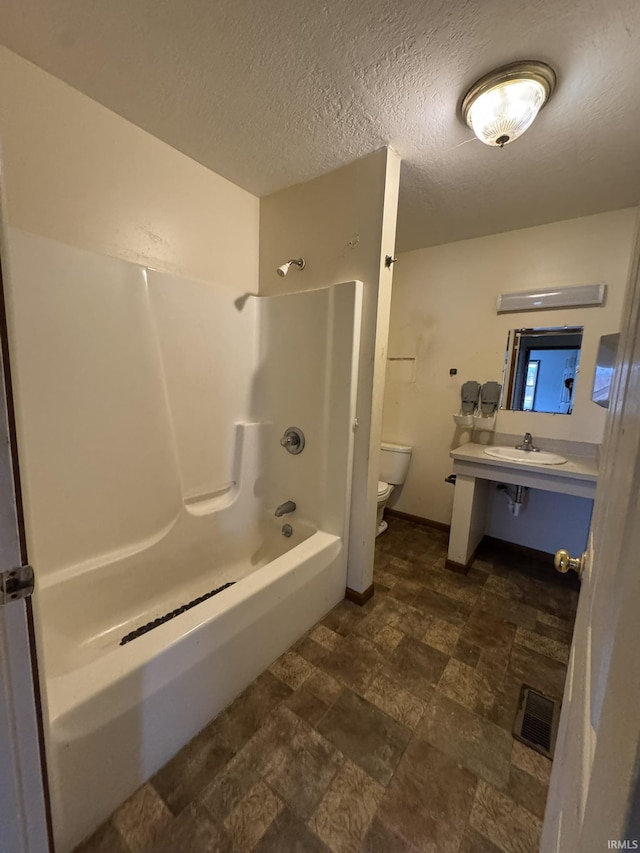 bathroom with baseboards, visible vents, toilet, a textured ceiling, and vanity