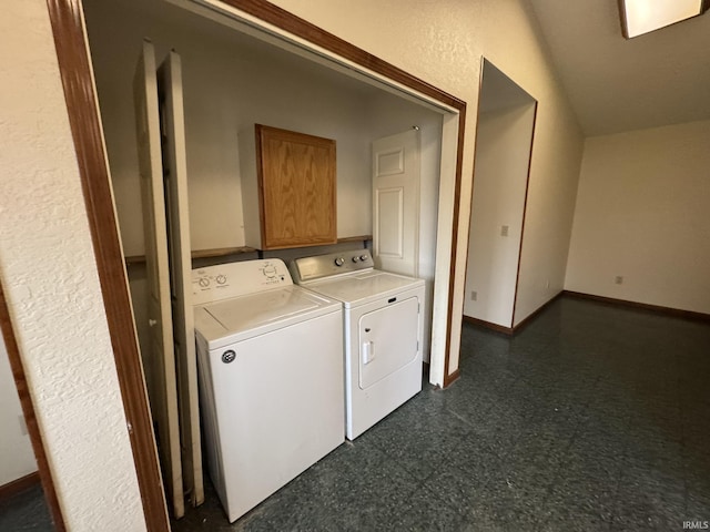 laundry room featuring baseboards, dark floors, and washer and dryer