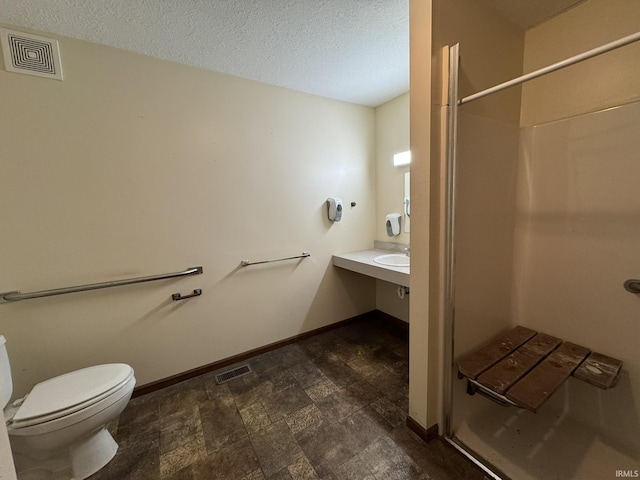 full bathroom with visible vents, baseboards, toilet, a textured ceiling, and a shower stall