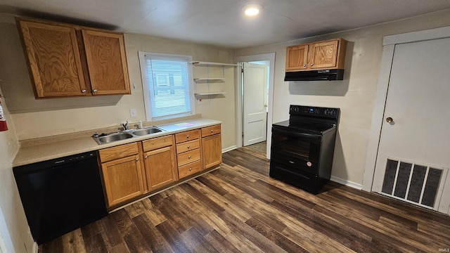 kitchen featuring dark wood-style floors, visible vents, a sink, under cabinet range hood, and black appliances