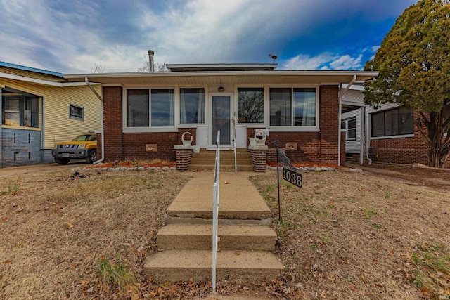 bungalow-style home featuring entry steps and brick siding