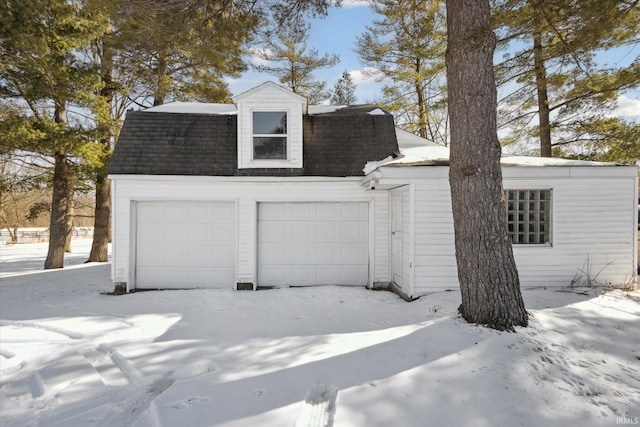 snow covered garage featuring a garage