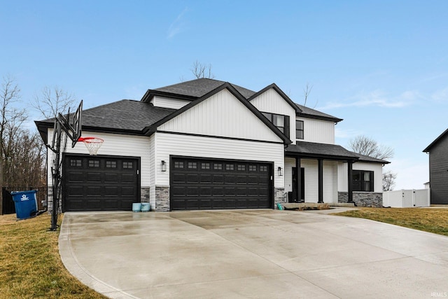 modern farmhouse style home featuring a garage, a shingled roof, driveway, stone siding, and a front yard