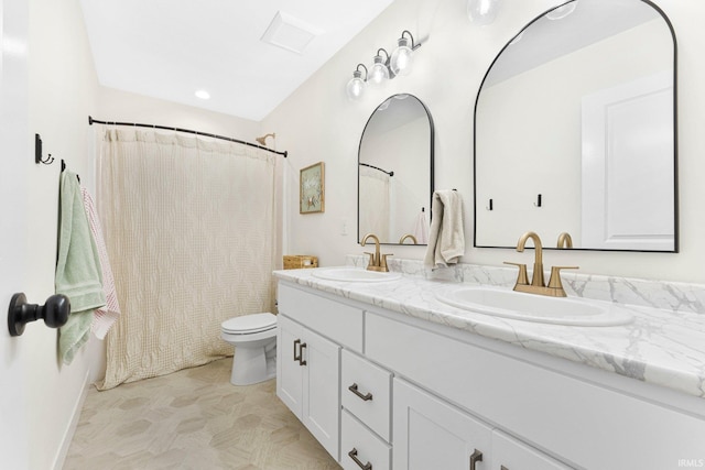 full bath with double vanity, a sink, and toilet