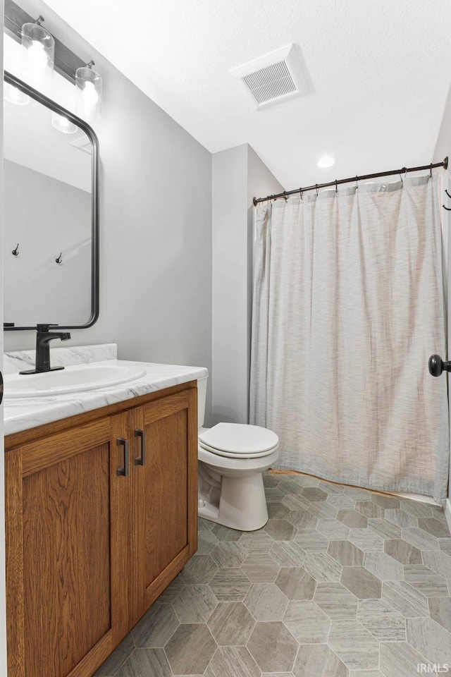 bathroom with toilet, curtained shower, vanity, and visible vents