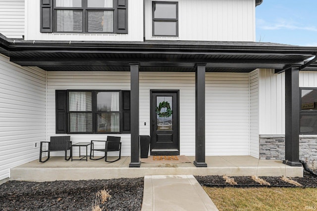 doorway to property featuring stone siding and a porch