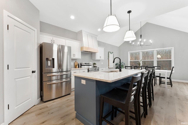 kitchen with white cabinets, light wood-style flooring, stainless steel appliances, and a sink