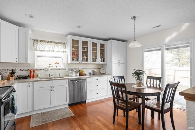 kitchen with light countertops, visible vents, appliances with stainless steel finishes, a sink, and wood finished floors