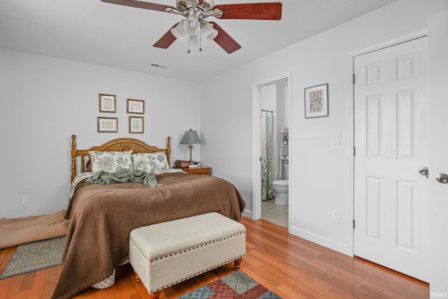 bedroom featuring ceiling fan, connected bathroom, visible vents, baseboards, and light wood finished floors