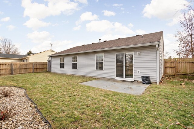 back of property with a fenced backyard, a lawn, and a patio