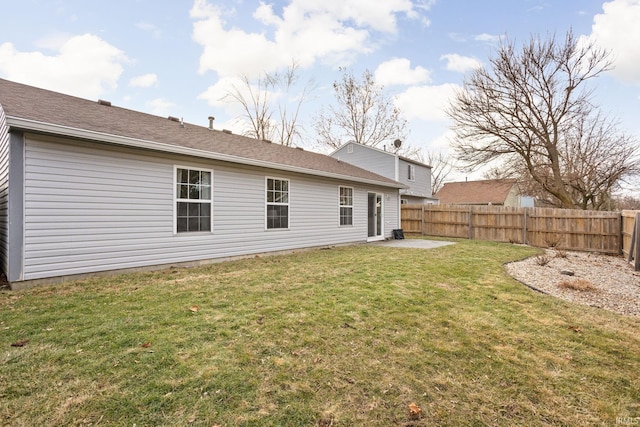 back of property featuring fence, a patio, and a lawn