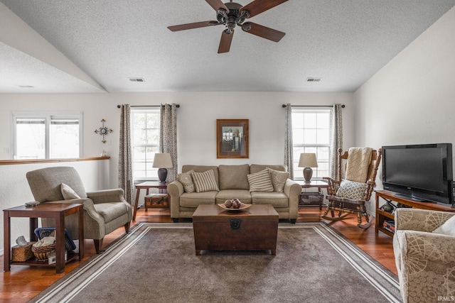 living room with a textured ceiling, wood finished floors, a wealth of natural light, and a ceiling fan