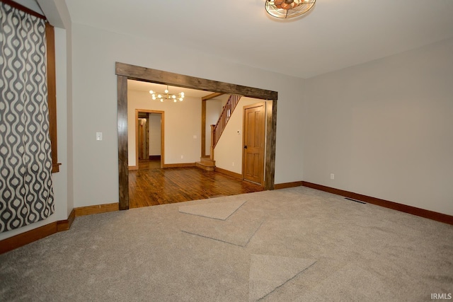 empty room featuring stairs, carpet floors, and baseboards