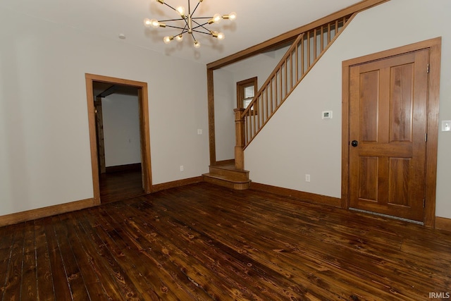 unfurnished room featuring a chandelier, wood-type flooring, stairway, and baseboards