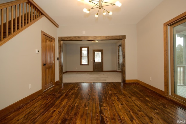 entryway featuring hardwood / wood-style flooring, baseboards, and a notable chandelier