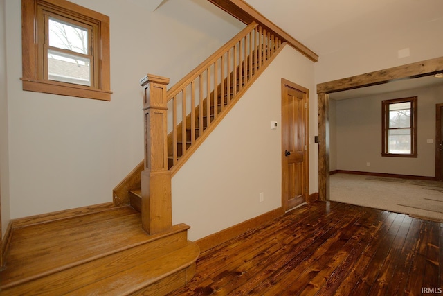 staircase featuring wood-type flooring and baseboards